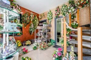 Intérieur du magasin funéraire avec des fleurs de deuil artificielles et un escalier en bois