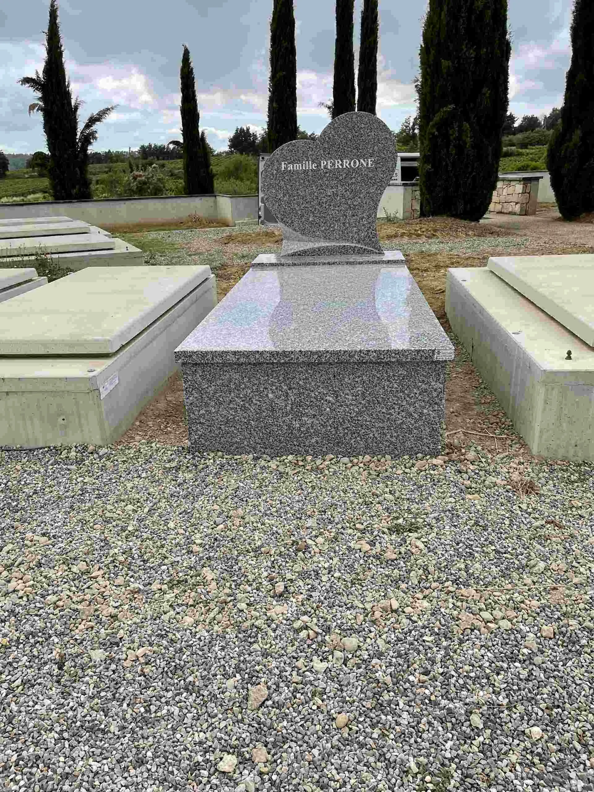 Pierre tombale en granit gris granitique avec stèle taillée en forme de cœur gravée